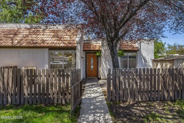 a front view of a house with a tree
