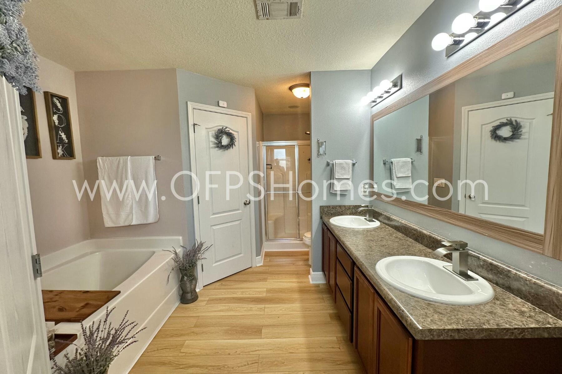 2400 Avenida De Sol Navarre, FL 32566 - Photo 17 of 42 a spacious bathroom with a granite countertop double vanity sink a mirror a bathtub and shower