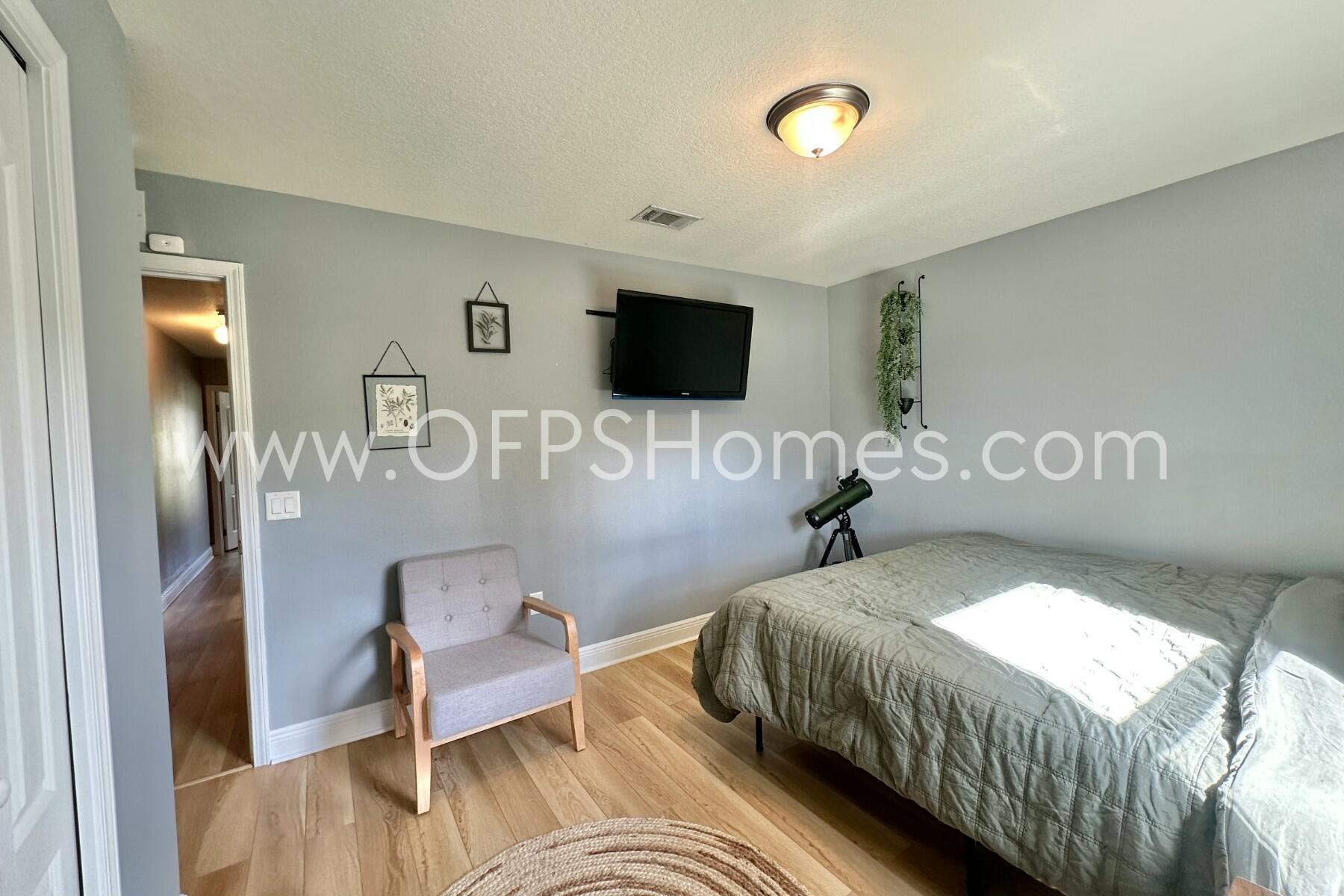 2400 Avenida De Sol Navarre, FL 32566 - Photo 21 of 42 a bedroom with a bed and a flat screen tv