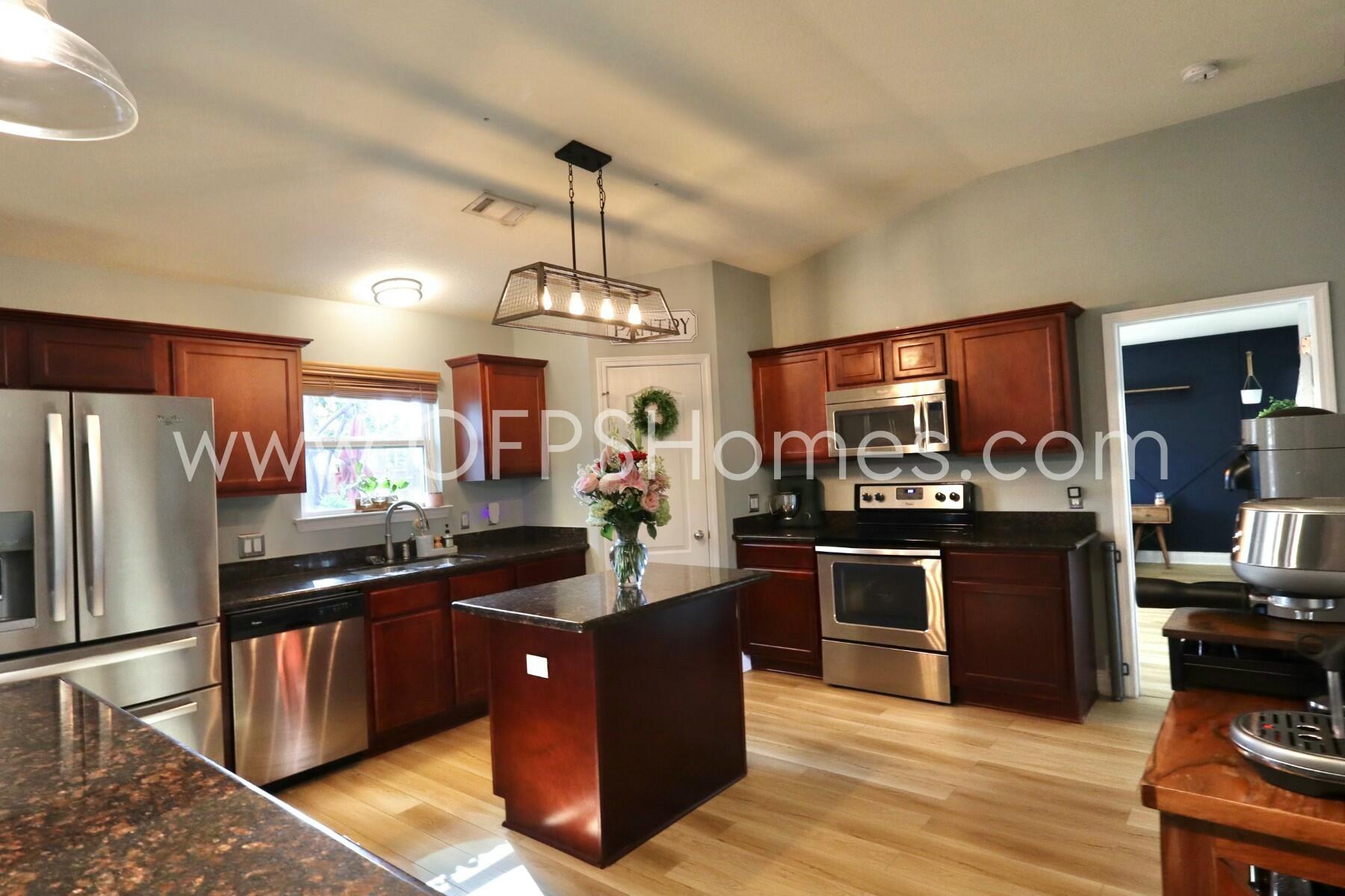 2400 Avenida De Sol Navarre, FL 32566 - Photo 10 of 42 a kitchen with stainless steel appliances granite countertop a stove refrigerator and cabinets