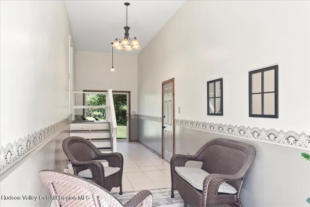 a living room with furniture chandelier and a large window