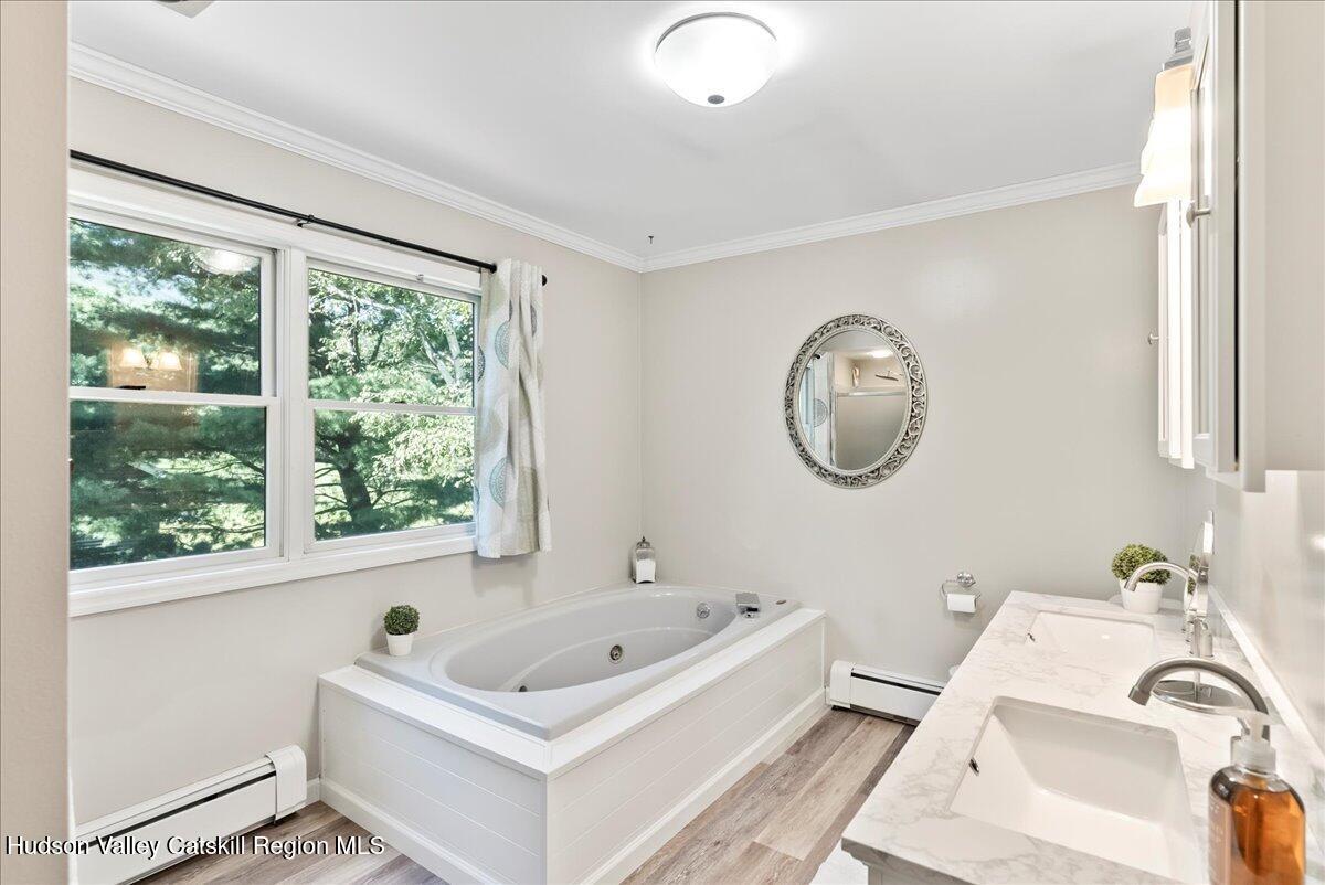 29 Stone Mountain Road Round Top, NY 12473 - Photo 20 of 36 a bathroom with a bathtub a mirror a sink and a window
