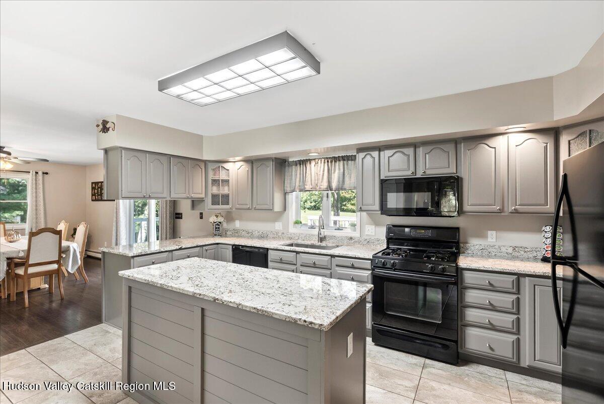 29 Stone Mountain Road Round Top, NY 12473 - Photo 8 of 36 a kitchen with stainless steel appliances granite countertop a stove top oven a sink dishwasher and a refrigerator with wooden floor
