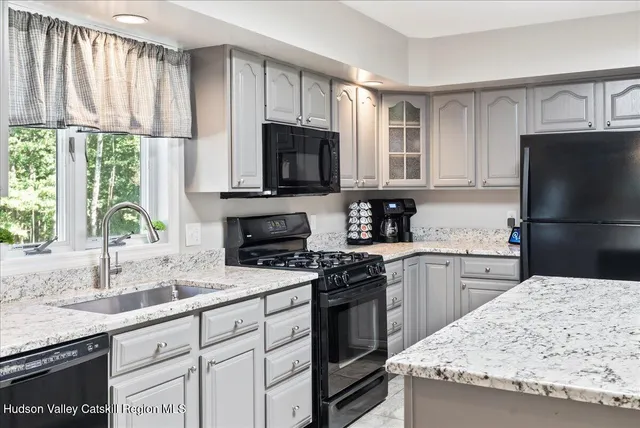 a kitchen with granite countertop a sink stainless steel appliances and cabinets