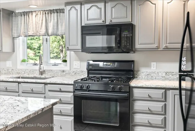 a kitchen with granite countertop white cabinets and appliances
