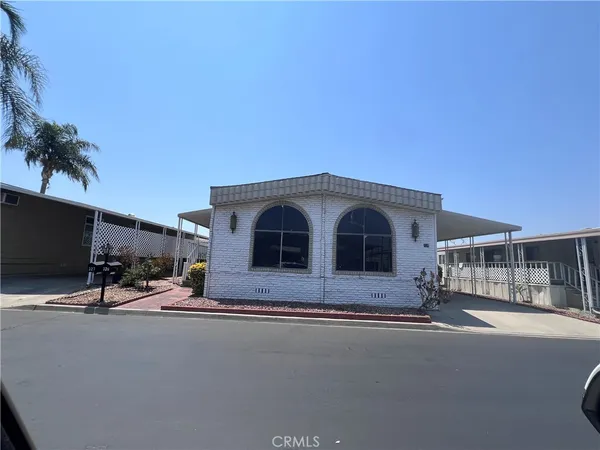 a front view of a house with yard and parking