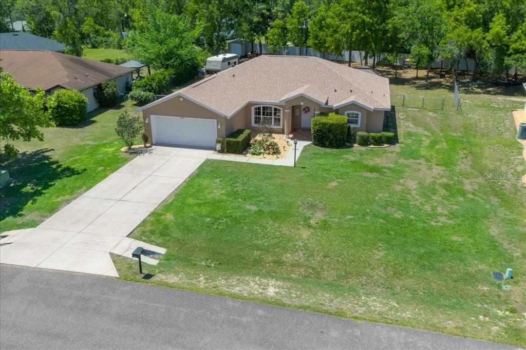 5321 Southwest 115th Loop Ocala, FL 34476 - Photo 2 of 49 a aerial view of a house next to a big yard and large trees