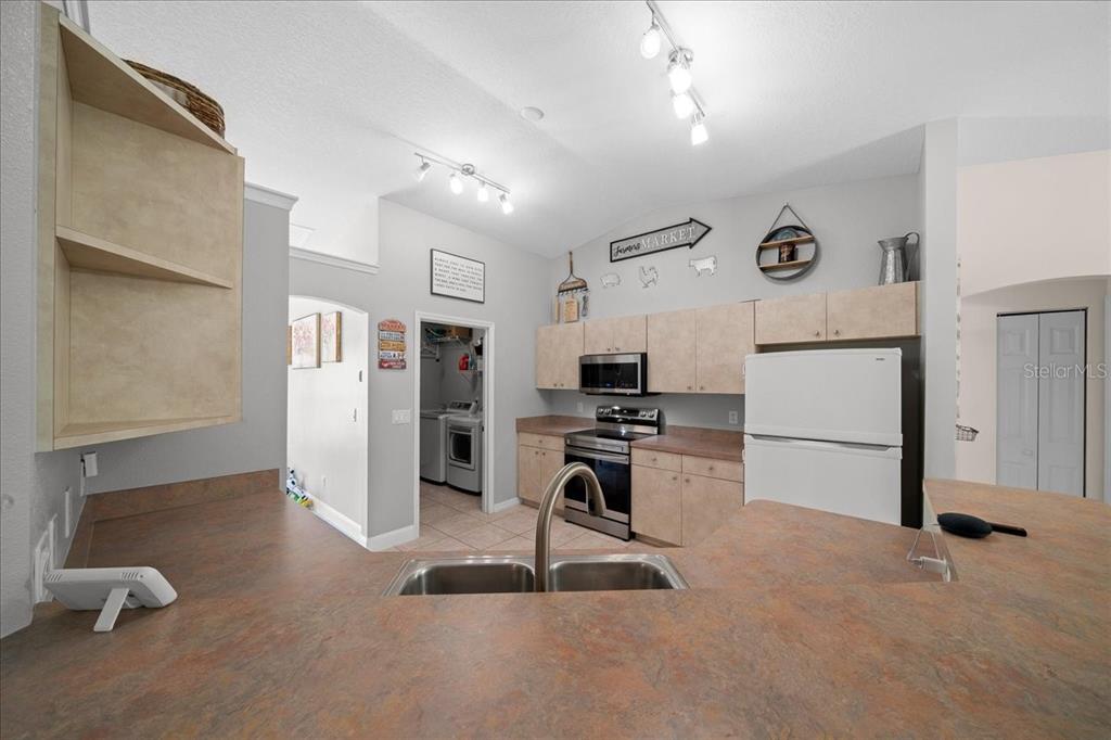 5321 Southwest 115th Loop Ocala, FL 34476 - Photo 21 of 49 a kitchen with stainless steel appliances granite countertop a refrigerator stove top oven a sink and dishwasher
