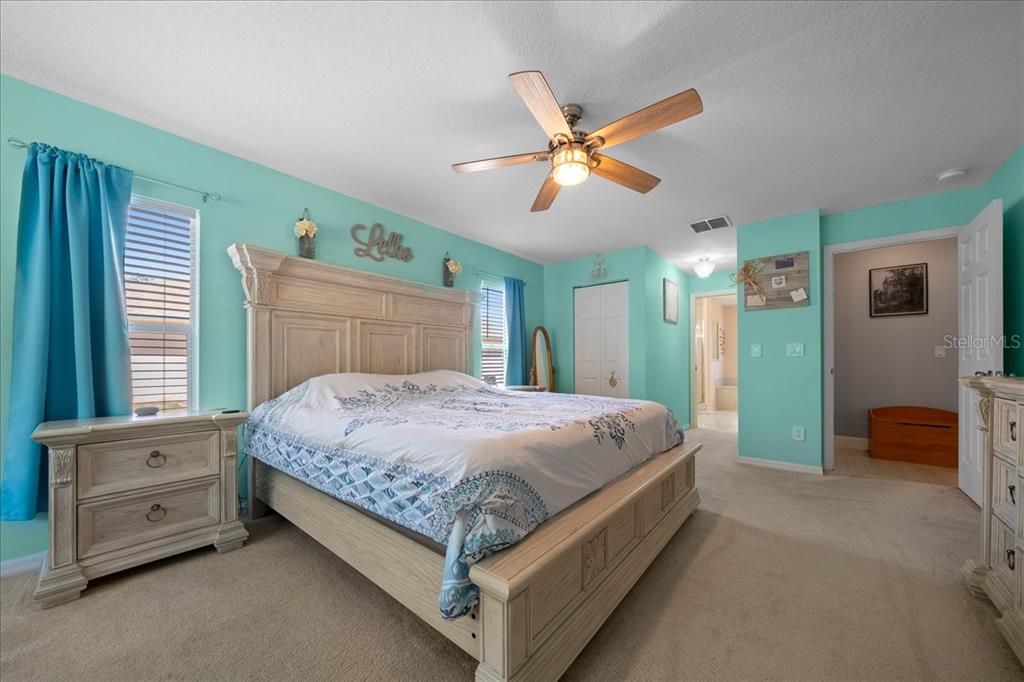 5321 Southwest 115th Loop Ocala, FL 34476 - Photo 25 of 49 a bedroom with a bed and a chandelier