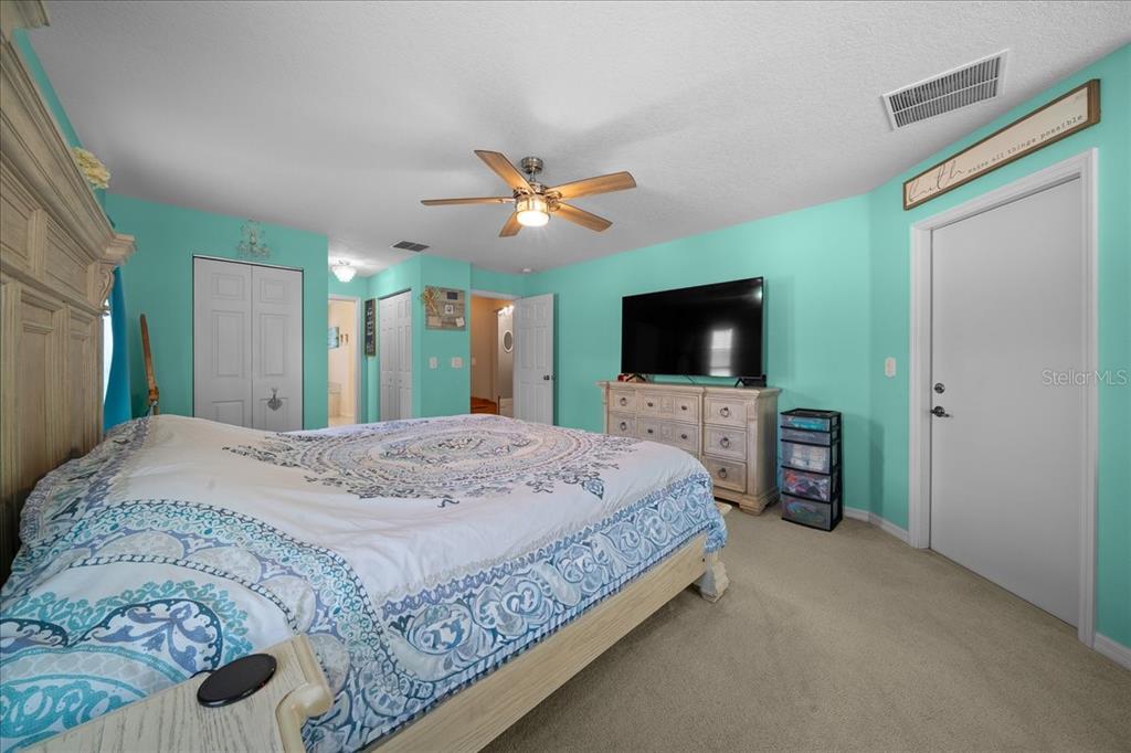 5321 Southwest 115th Loop Ocala, FL 34476 - Photo 26 of 49 a spacious bedroom with a bed and a flat screen tv