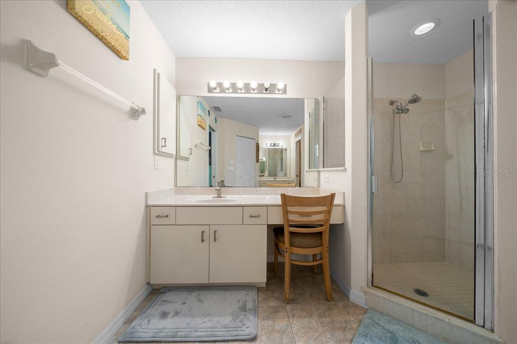 5321 Southwest 115th Loop Ocala, FL 34476 - Photo 30 of 49 a spacious bathroom with a granite countertop sink a mirror and a shower