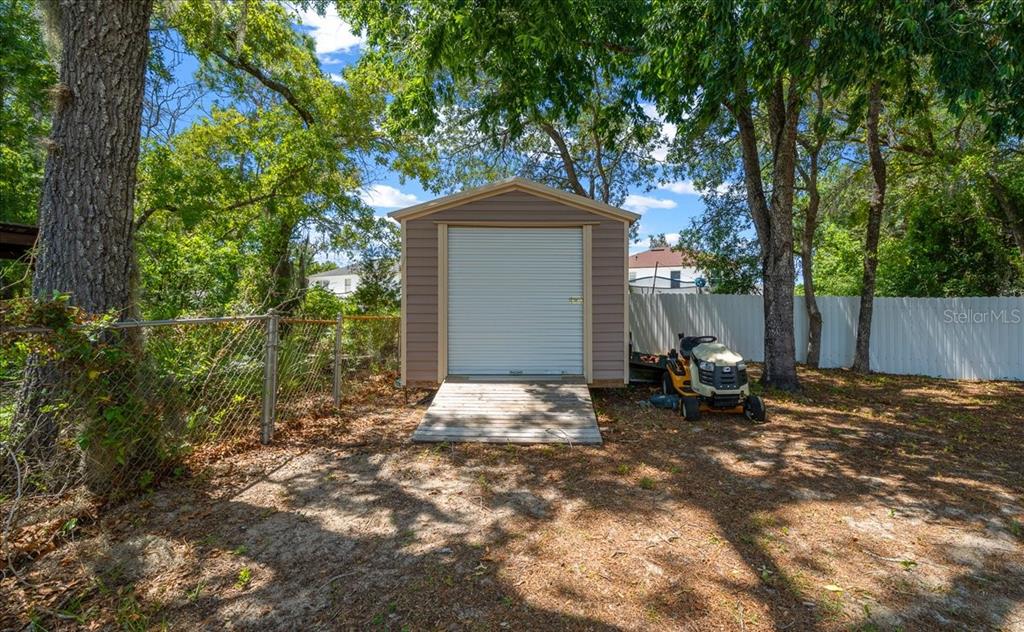 5321 Southwest 115th Loop Ocala, FL 34476 - Photo 43 of 49 a backyard of a house with table and chairs and a large tree