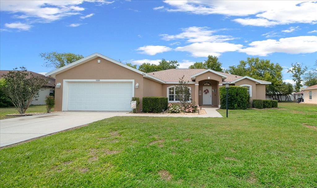 5321 Southwest 115th Loop Ocala, FL 34476 - Photo 7 of 49 a front view of a house with a garden and yard