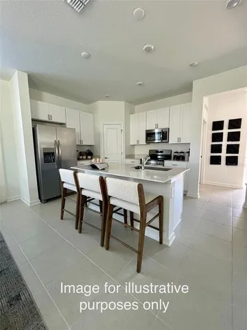 a kitchen with a table chairs a refrigerator and cabinets