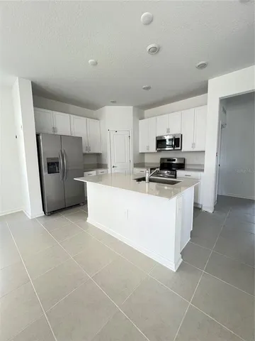 a kitchen with refrigerator and cabinets