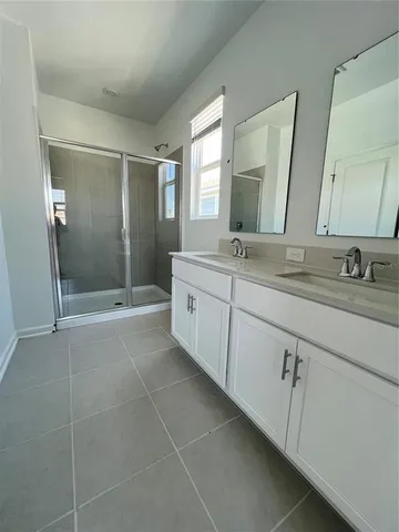a spacious bathroom with a shower sink and mirror