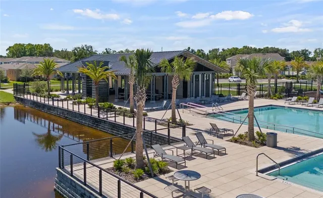 a view of a chairs and table in patio with swimming pool