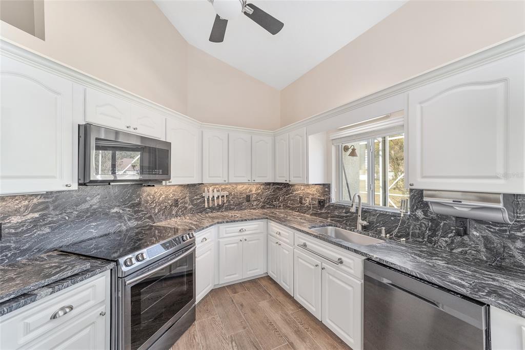 5565 Northwest 26th Lane Ocala, FL 34482 - Photo 19 of 59 a kitchen with stainless steel appliances granite countertop a sink stove and cabinets