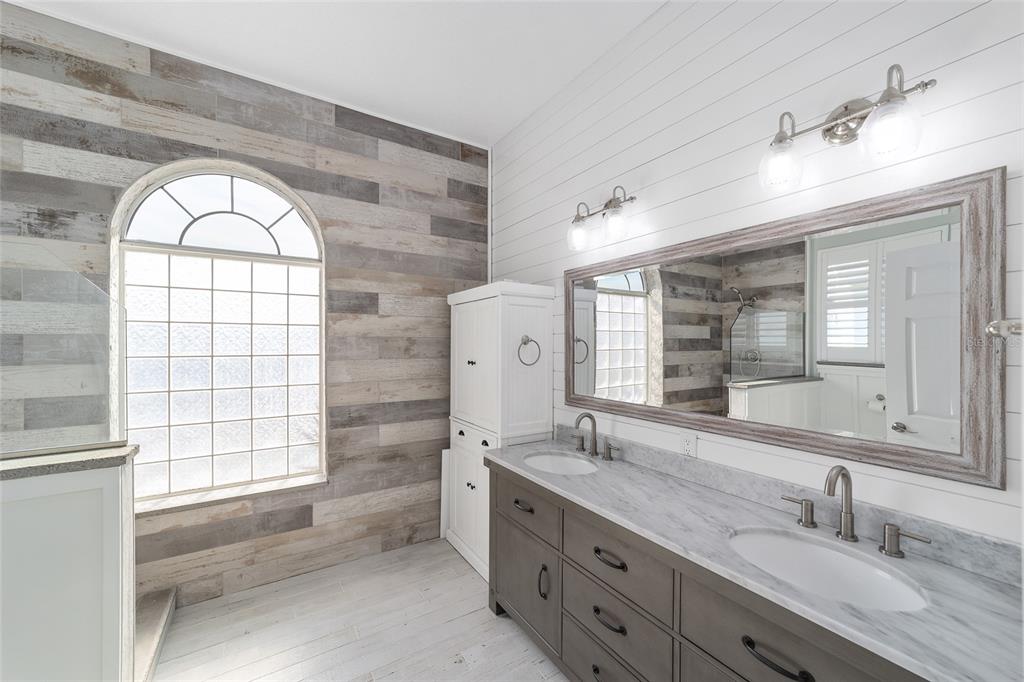 5565 Northwest 26th Lane Ocala, FL 34482 - Photo 25 of 59 a bathroom with a granite countertop sink a large mirror and a bathtub