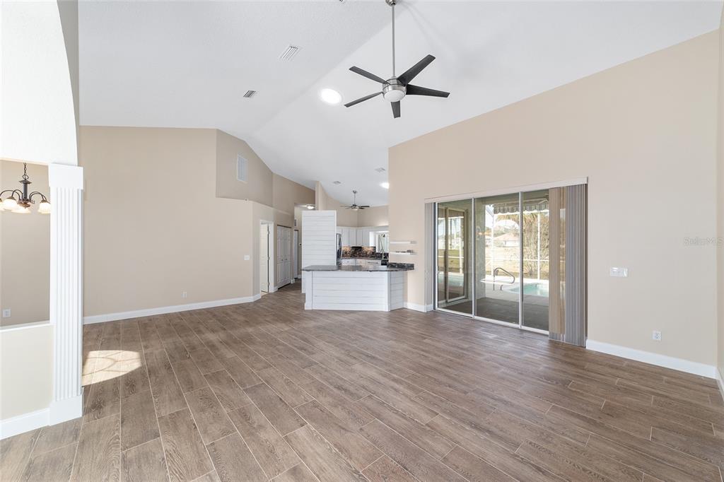 5565 Northwest 26th Lane Ocala, FL 34482 - Photo 9 of 59 a view of a kitchen with wooden floor and a ceiling fan