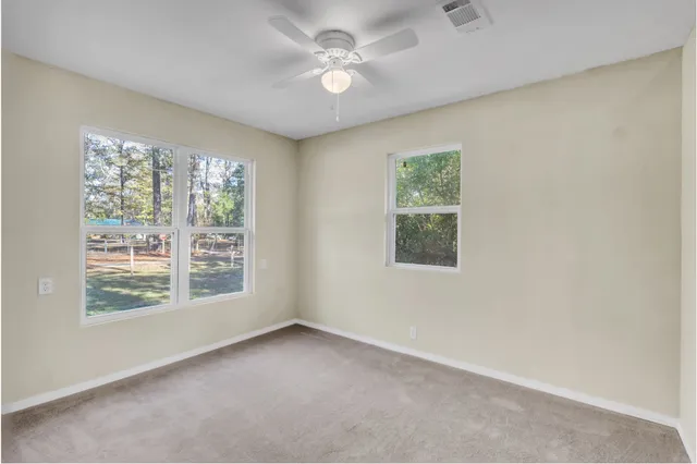 an empty room with a window and a ceiling fan