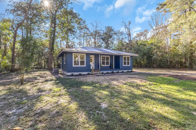 a view of a house with backyard and sitting area