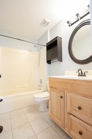a bathroom with a sink a toilet a mirror and shower