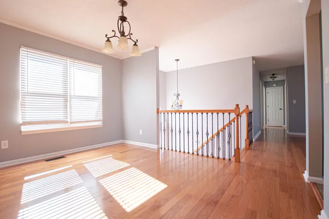 a view of a room with wooden floor and a window