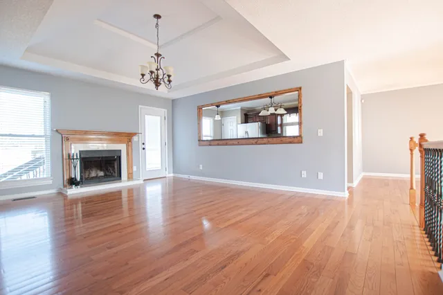 a view of empty room with wooden floor and fireplace