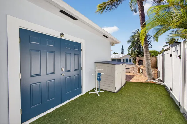 a view of a house with a yard and palm trees
