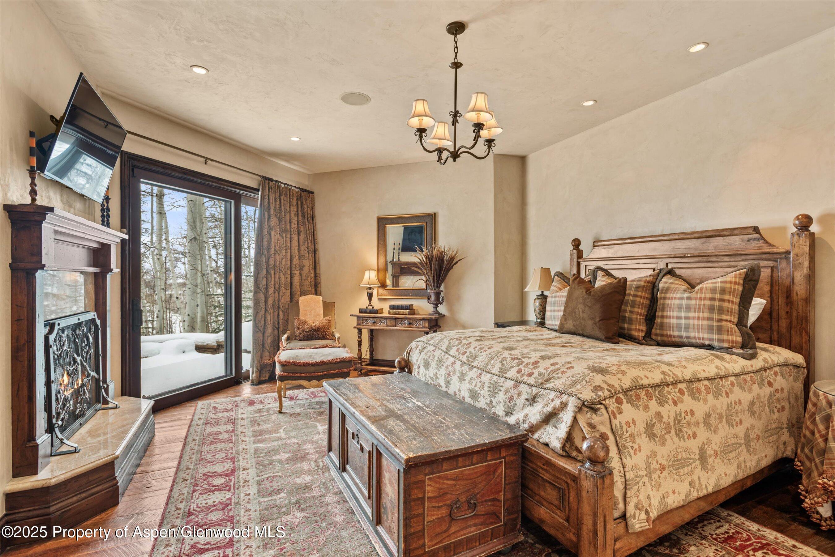 1777 Wood Road Snowmass Village, CO 81615 - Photo 12 of 27 a bedroom with a large bed and a chandelier