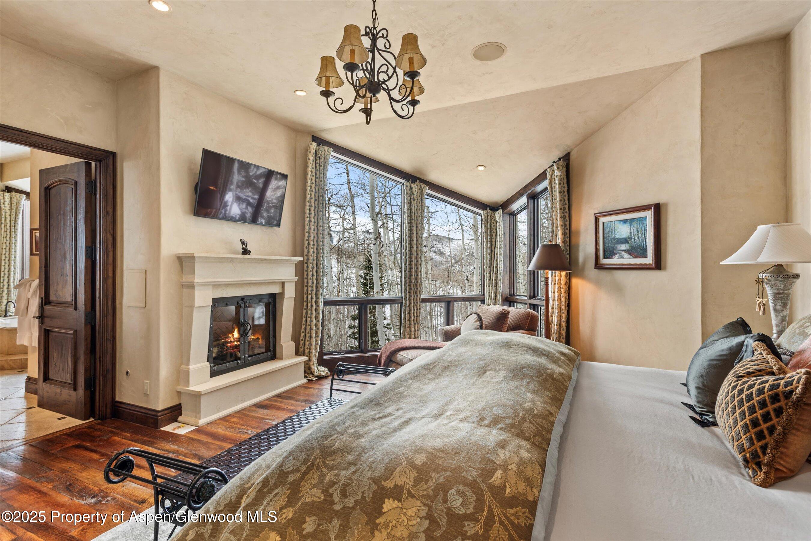 1777 Wood Road Snowmass Village, CO 81615 - Photo 10 of 27 a spacious bedroom with a bed and a fireplace