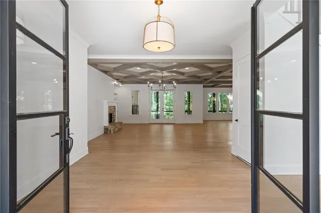 a view of a hallway with wooden floor and a chandelier