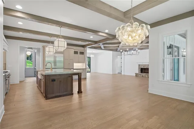 an empty room with wooden floor and chandelier