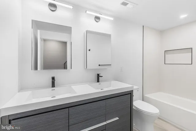 a bathroom with a toilet a sink and mirror