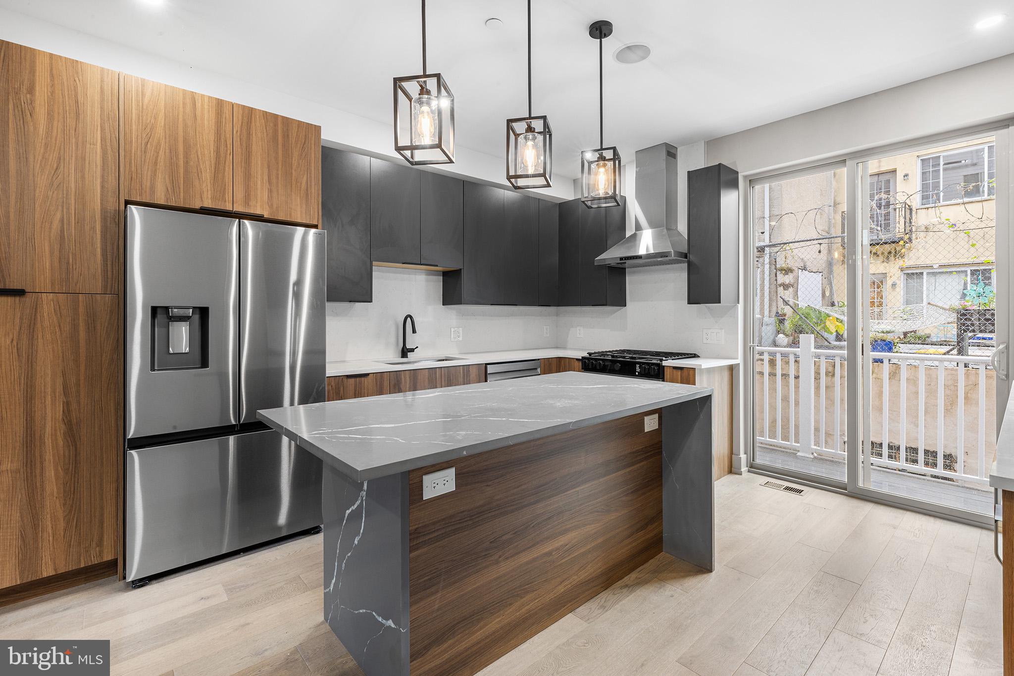 2340 Alter Street Philadelphia, PA 19146 - Photo 2 of 46 a kitchen with kitchen island a counter top a stove a refrigerator and a view of living room