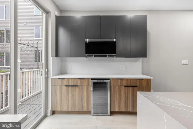 a living room with a stove and a refrigerator