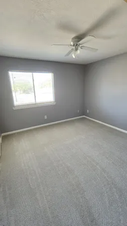 an empty room with a window and a projector screen