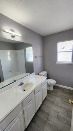 a bathroom with a double vanity sink and a toilet