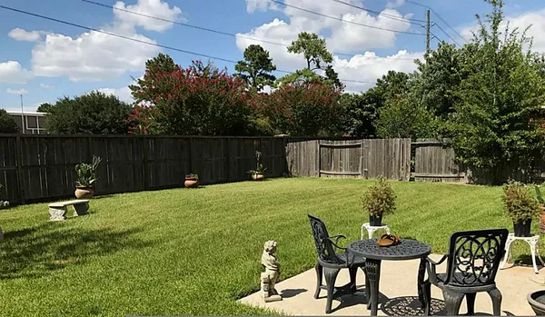a backyard of a house with table and chairs