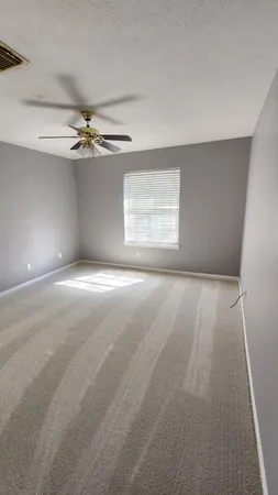 a view of a livingroom with a ceiling fan and window