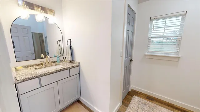 a bathroom with a granite countertop sink and a mirror