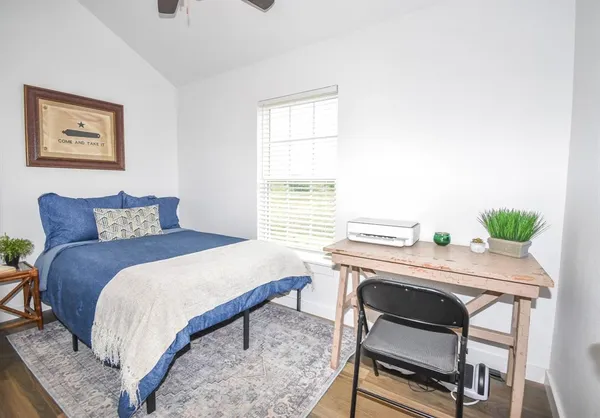 a bedroom with a bed table and chair