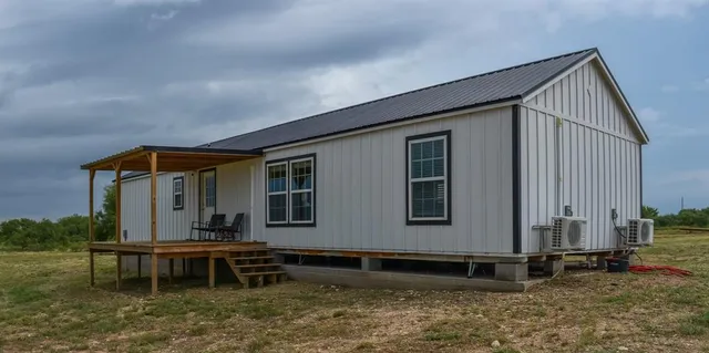 a view of house with yard and sitting area