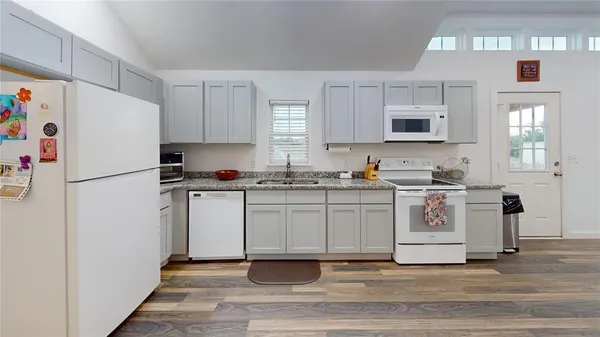 a kitchen with white cabinets and white appliances