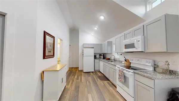 a kitchen with white cabinets sink and stainless steel appliances