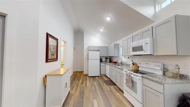 a kitchen with white cabinets sink and stainless steel appliances