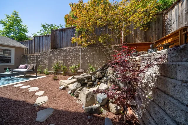 a view of backyard with wooden fence and trees