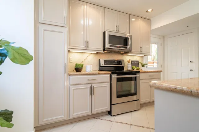 a kitchen with white cabinets and stainless steel appliances