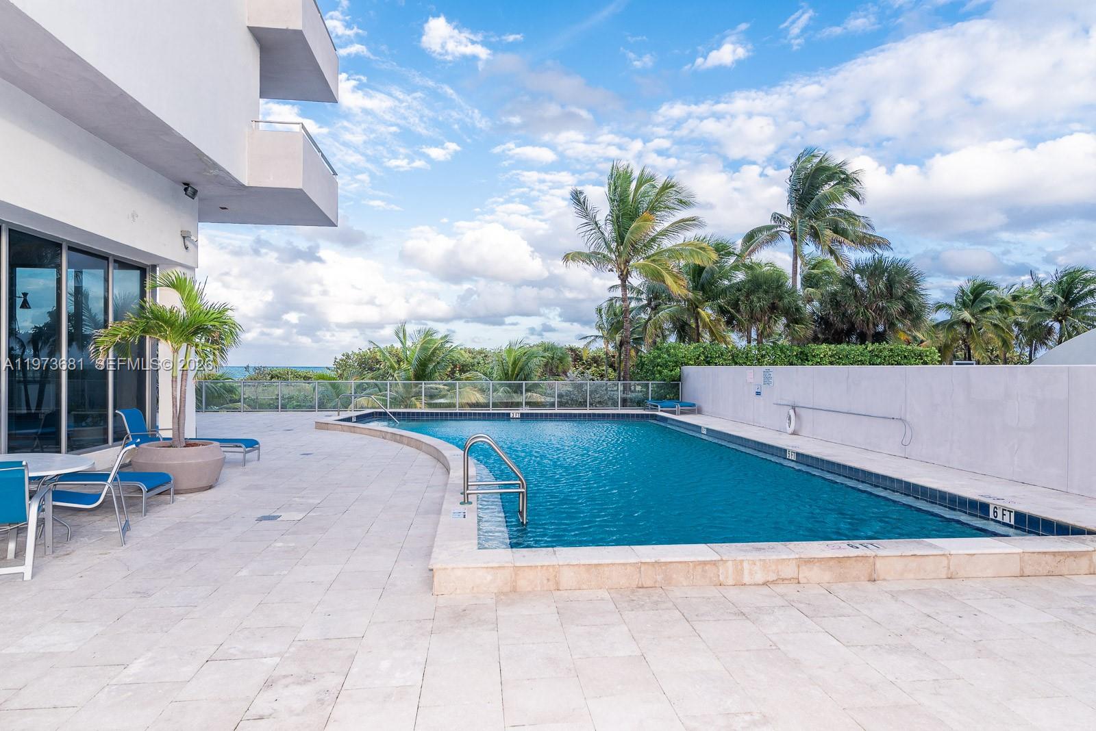 9225 Collins Avenue, Unit 1010 Surfside, FL 33154 - Photo 4 of 25 a view of a swimming pool and lounge chair